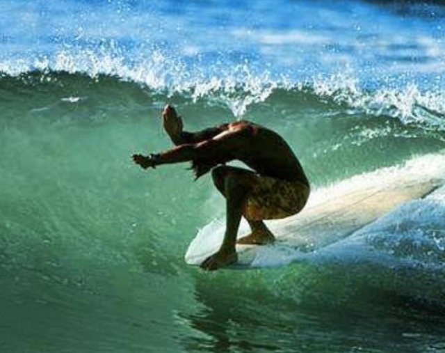 hombre agachado mientras surfea